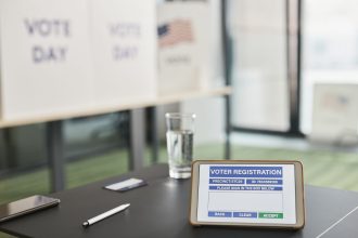 Tablet exibe uma tela de cadastro digital de eleitor em um posto de votação.